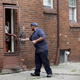 A worker from Homrich talks to a resident on Aug. 27, 2014, in Detroit after turning their water back on. It was disconnected by the Detroit Water and Sewerage Department, which disconnected water to thousands of Detroit residents with delinquent bills.